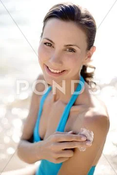 Woman applying sunscreen Stock Photos