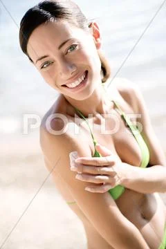 Woman applying sunscreen Stock Photos