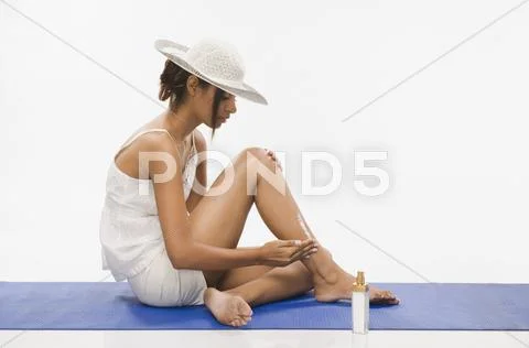 Woman applying suntan lotion Stock Photos