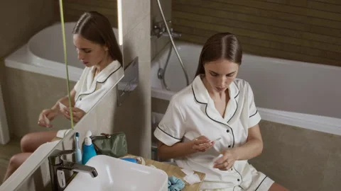 Woman Applying Transdermal Patch to Her Body in Bathroom 스톡 동영상 323691828