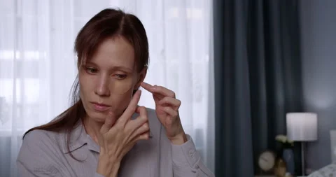 Woman applying under eye patch at home Vídeos de archivo 196874837