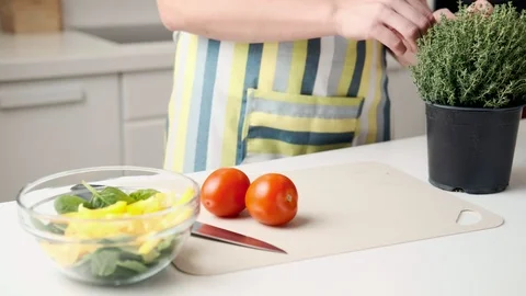 A woman in an apron in the kitchen preparing a vegetable salad Stock Footage 106097088