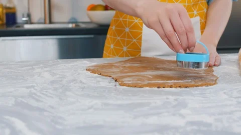 Woman in apron using cookie cutter to cut dough in round shapes Stock Footage 129326437