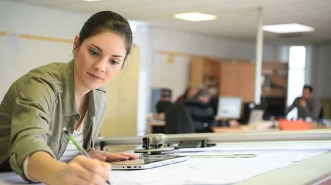 Woman architect working on drawing table in office Stock Footage