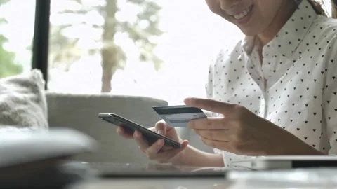 Woman are using smartphone and doing online transactions at home Woman doing Stock Footage 265928853