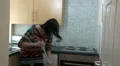 Woman arguing as she sweeps kitchen HD Footage