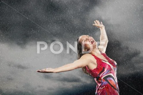 Woman With Arms Outstretched Enjoying The Rain Stock Photos