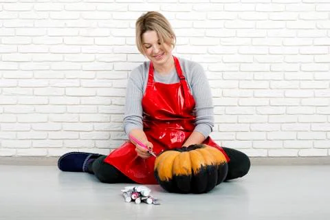 A woman artist prepares for halloween and paints pumpkins Photos