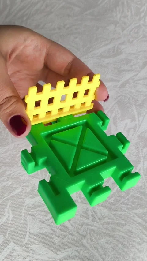 A woman assembles a close-up of a construction set on a table. Games for Stock Footage 318205393