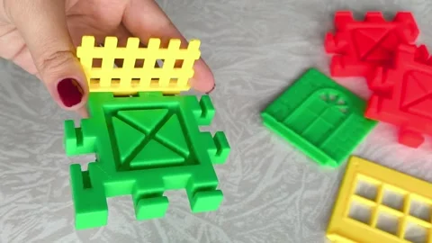 A woman assembles a close-up of a construction set on a table. Games for Stock Footage 318205471