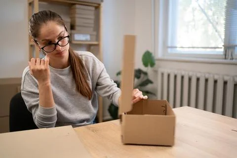 Woman assembling boxes for start-up. Cardboard box. Self-assembly. Stock Photos