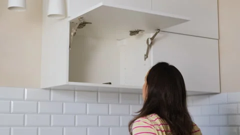 Woman assembling kitchen cabinet with tools Stock Footage 317321331