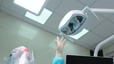 Woman assistant adjusts the lighting before checking the teeth of the client 動画素材 133561814