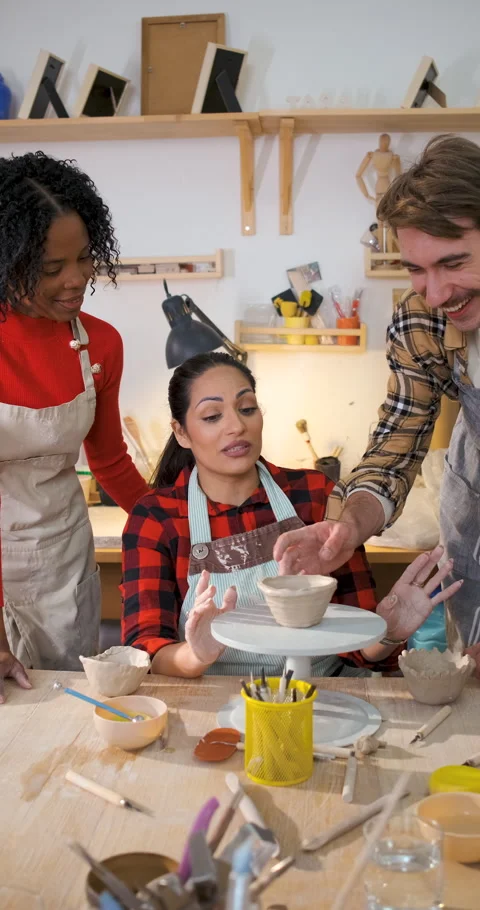Woman attending pottery class explains the process of making clay shapes to.. Stock Footage 345207407