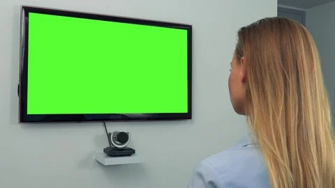 A woman (the back of her head to the camera) looks at a green television screen Vídeo Stock 72002151