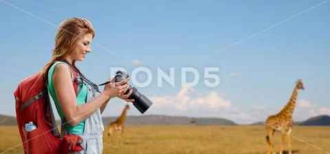 Woman with backpack and camera over savannah Stock Photos
