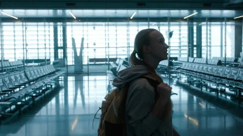 Woman with backpack going along the empty rows of seats at the airport Video stock 231139447