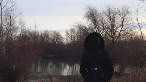 Woman with Backpack Walking Down to Cold River in Autumn Time Slow motion Stock Footage 291947636
