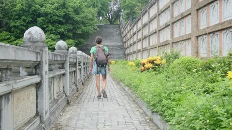 Woman with backpack walking through Southeast Asian temple Stock Footage 248513822