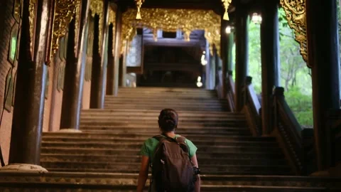 Woman with backpack walking through Southeast Asian temple Stock Footage 248513911