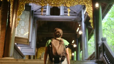 Woman with backpack walking through Southeast Asian temple Stock Footage 248513958