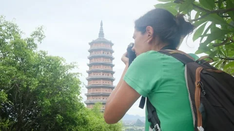 Woman with backpack walking through Southeast Asian temple Stock Footage 248514530
