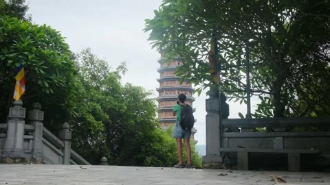 Woman with backpack walking through Southeast Asian temple Stock Footage 248514540