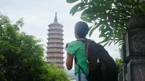 Woman with backpack walking through Southeast Asian temple Stock Footage 248514548
