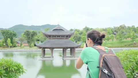 Woman with backpack walking through Southeast Asian temple Stock Footage 248515893