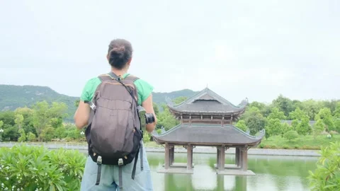 Woman with backpack walking through Southeast Asian temple Stock Footage 248515896