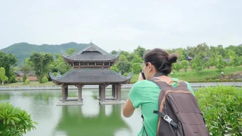 Woman with backpack walking through Southeast Asian temple Stock Footage 248515931