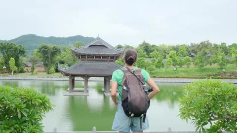Woman with backpack walking through Southeast Asian temple Stock Footage 248515960