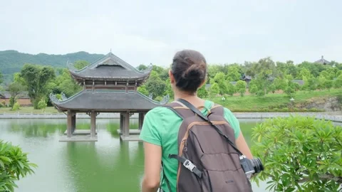 Woman with backpack walking through Southeast Asian temple Stock Footage 248515984