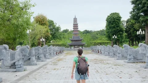 Woman with backpack walking through Southeast Asian temple Stock Footage 248516018