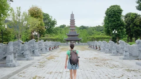 Woman with backpack walking through Southeast Asian temple Stock Footage 248516041