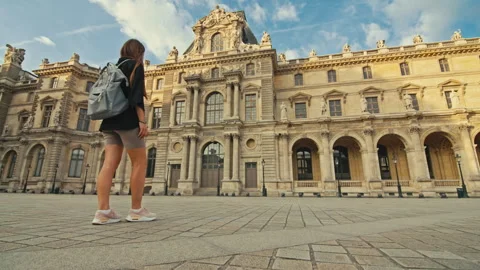 A woman with a backpack walks through a square with art galleries in Paris. Stock Footage 313365598