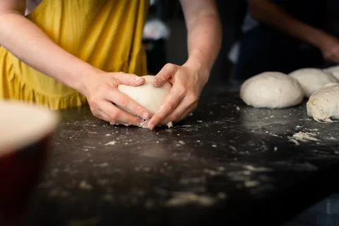 Woman baker forms bread on a table Stock Photos