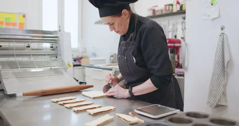Woman baker preparing raw dough for pastry on baking manufacture Stock Footage 237908077