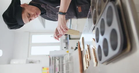 Woman baker preparing raw dough for pastry on baking manufacture Vertical shot Stock Footage 237908094