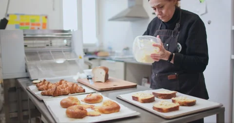 Woman baker preparing raw dough for pastry on baking manufacture Stock Footage 237967960