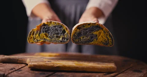 Woman baker shows rustic artisan homemade crusty sourdough pumpkin bread video Video stock 320432970