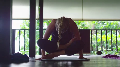 Woman balancing on her hands while performing yoga Stock Footage 74778970