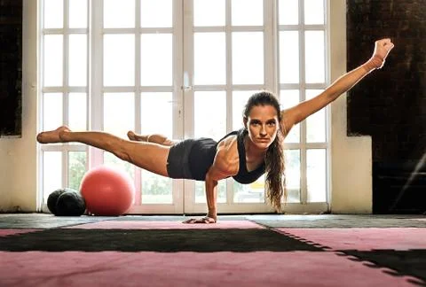 Woman balancing while doing a one hand push up showing strength and determina Foto stock