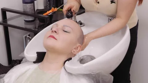 A woman in a barbershop is washing her head after shaving Stock Footage