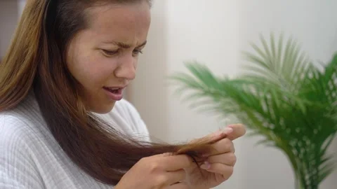 Woman, in a bathrobe, upset confronts split ends and the emotional turmoil of Stock Footage 250124194