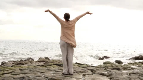 Woman at the beach with arms wide open, freedom concept Stock Footage
