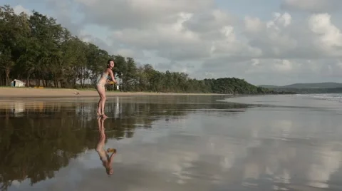 Woman on beach throwing frisbee in slow motion Stock Footage 61140073