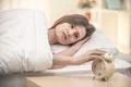 The woman in the bed turn off the alarm Photo