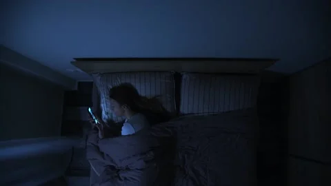 Woman in bed using smartphone at night. Stock Footage 147104335