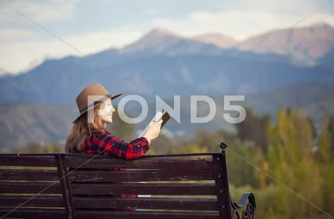 Woman on the bench with book Stock Photos